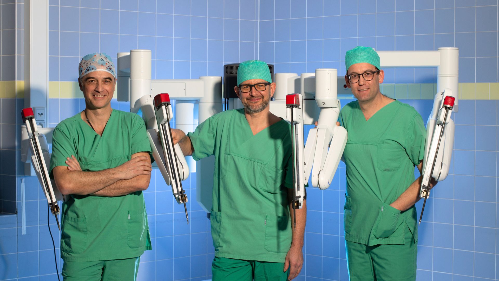 Drei Chirurgen aus dem Marien Hospital Düsseldorf stehen am Da Vinci OP-Roboter