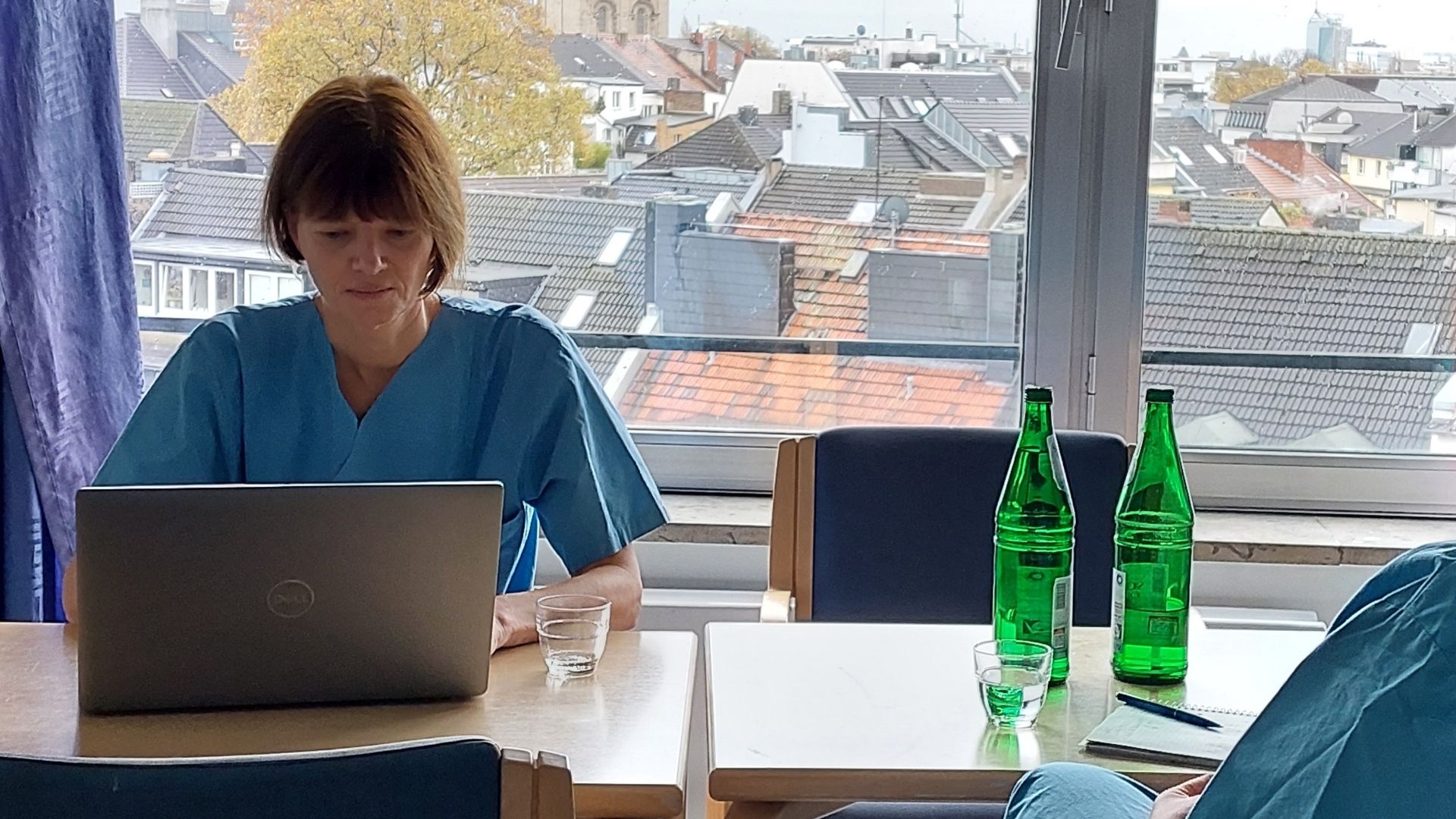 Eine Pflegewissenschaftlerin sitzt im Krankenhaus an ihrem Laptop